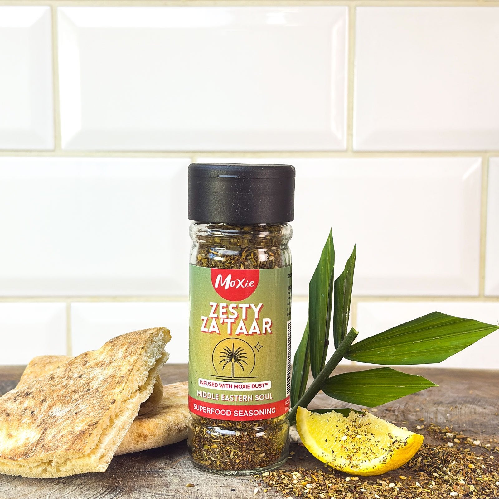 Moxie Zesty Za’taar Superfood Seasoning bottle with flatbread and lemon wedge