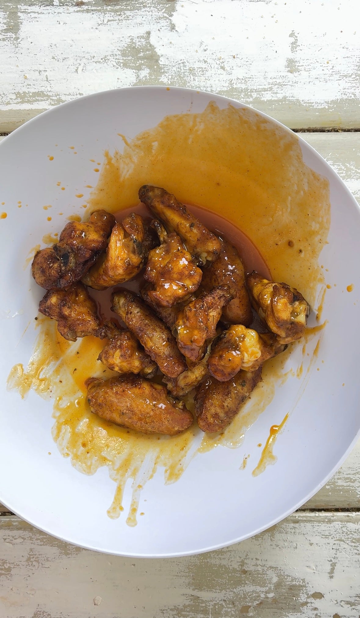 Tossing crispy chicken wings in homemade buffalo sauce with Moxie Swicy seasoning for a sweet and spicy glaze.