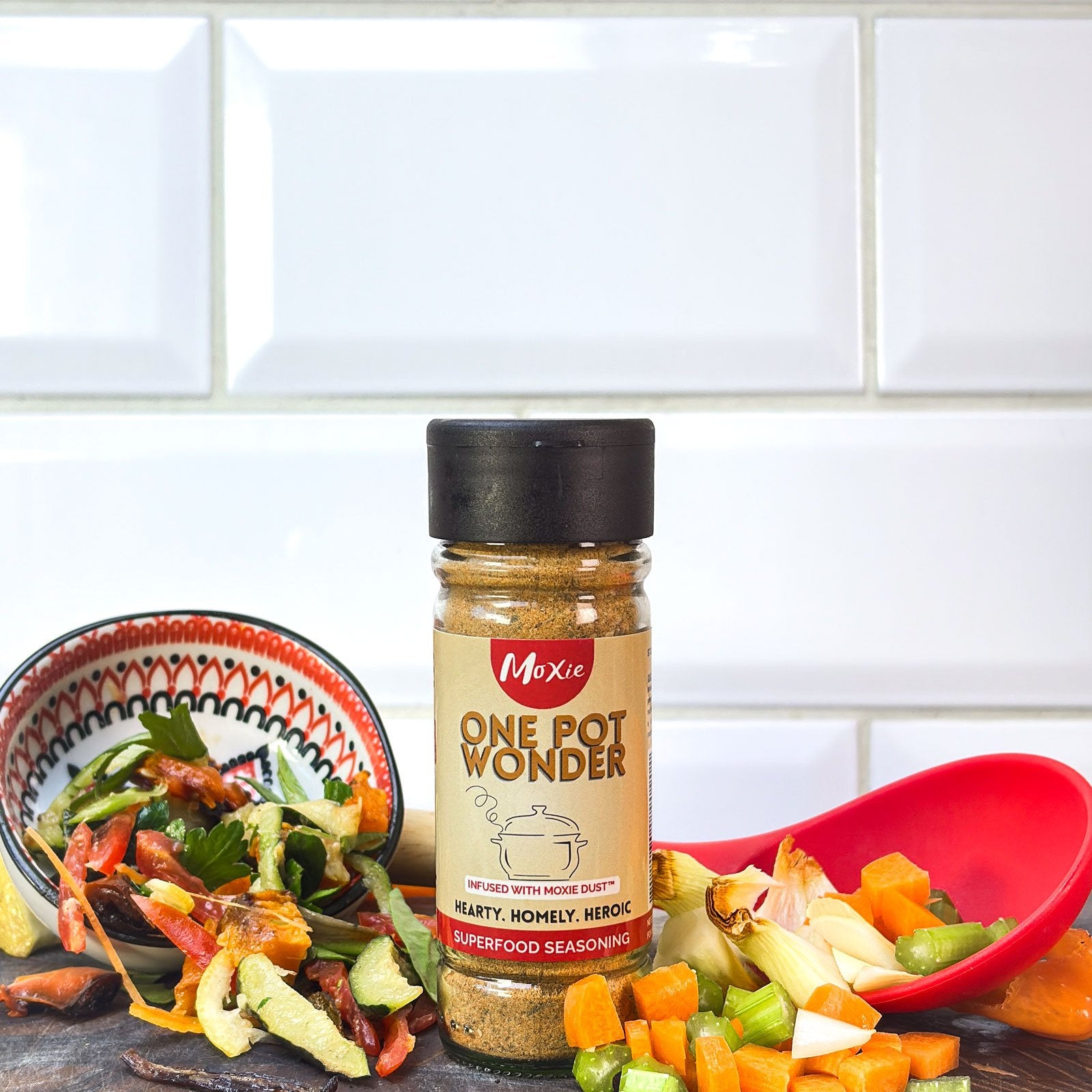 Moxie One Pot Wonder Superfood Seasoning bottle with colourful vegetables on kitchen counter